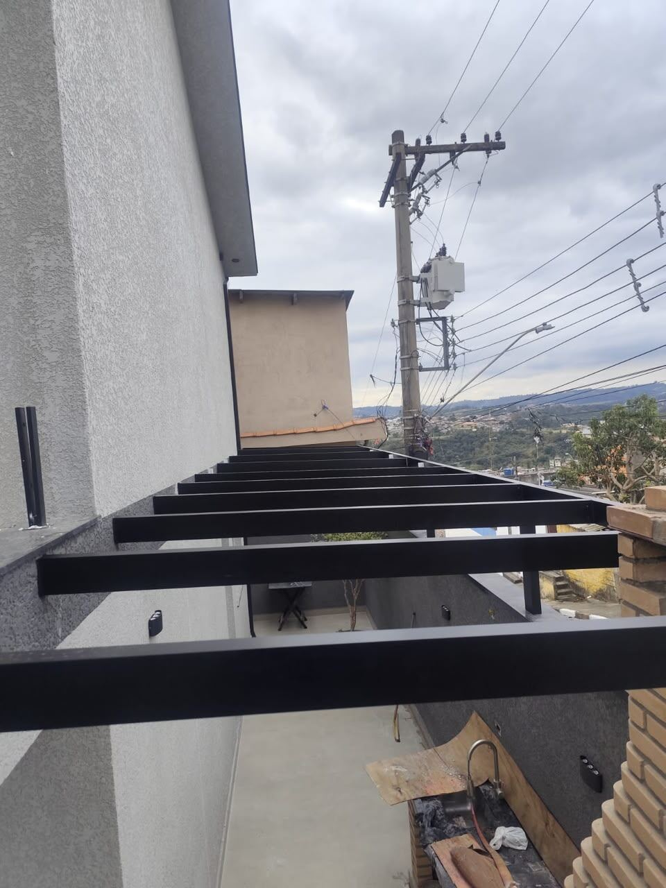 Instalação de estrutura para cobertura de vidro em quintal