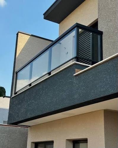 Guarda-corpo de vidro com esquadria preta em sacada residencial